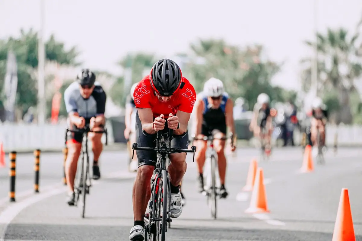 Groupe de cyclistes en plein effort dans un virage serré en triathlon